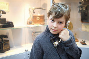 Portrait of a boy with old handset in the museum