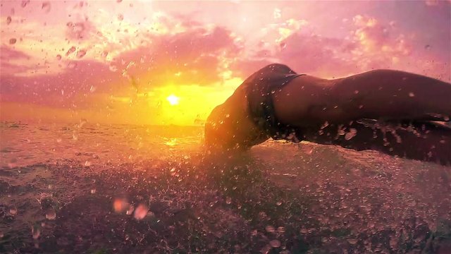 Young men jumping in the sea at sunset, SLOW MOTION