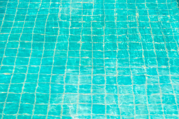 Blue-green swimming pool bottom with water wave texture