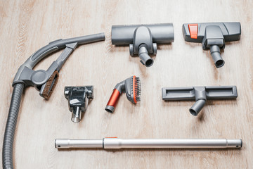 Hoover vacuum circuit with different nozzles stands on laminate floor at home
