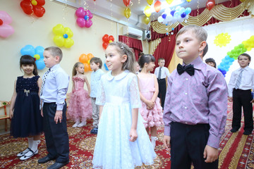 Twelve elegant young children standing at the feast in kindergarten