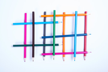 colorful pencils organized in a geometric form on white backgrou