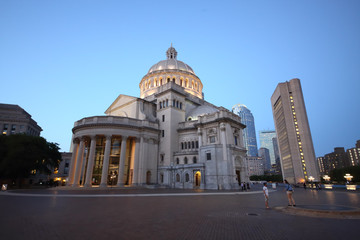 Mary Baker Eddy Library and Christian Science Mother Church near pond at autumn evening.