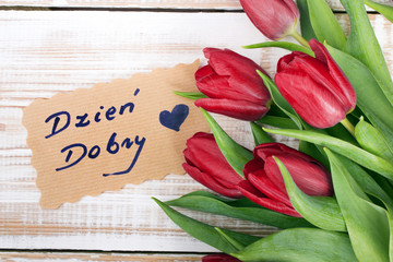 Polish words Good morning and bouquet of tulips on wooden background