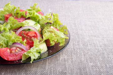 Side view of a plate of fresh salad of raw vegetables closeup