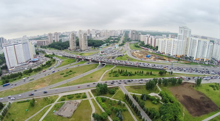 Townscape with transport traffic on interchange at spring cloudy day. Aerial view