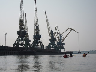 Obraz premium Kayaking in the river Danube near the port cranes