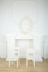 Interior white room with columns in ancient style, fireplace, openwork frame and chairs