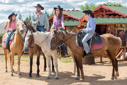 cowboy family of four on horses