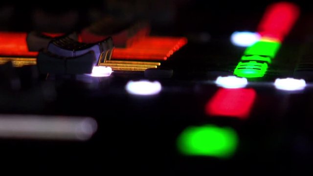  footage of a recording studio´s audio console and a hand pulling up the knobs/The audio console