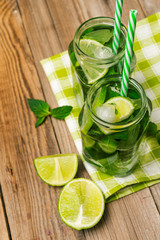Glasses with mojito and  ice on wooden background