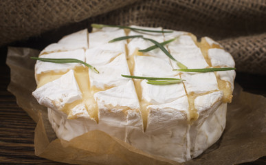 Camembert with rosemary on a wooden board