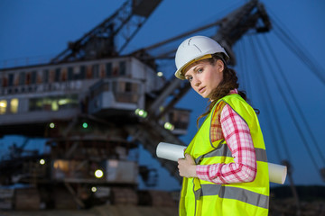 female worker holding scheme on rails on backgroud of career stacker