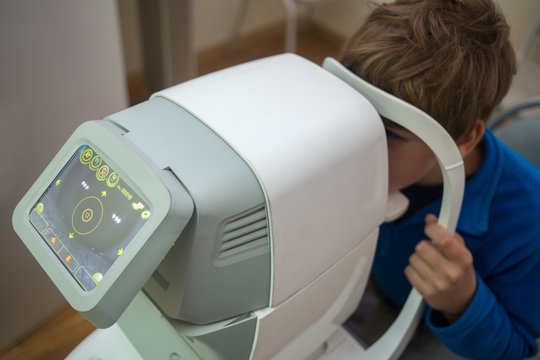 boy tests his eyes at Auto-Ref-Keratometer