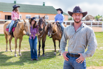 cowboy with wife and children on horses