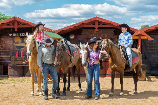 cowboy family of four with horses