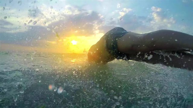 Young men jumping in the sea at sunset, SLOW MOTION
