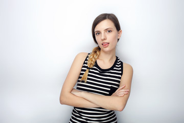 Fototapeta premium Portrait of naughty young beautiful woman in striped shirt crossed hands showing tongue posing for model tests against studio background