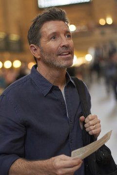 Caucasian man reading train schedule in Grand Central Station, New York City, New York, United States