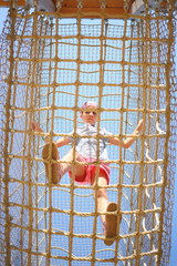 The girl inside the cable cell in playground, bottom view