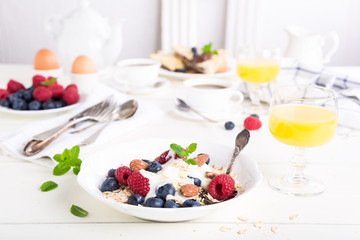 Healthy breakfast. Oat flakes with fresh berries , yogurt and honey on white table.