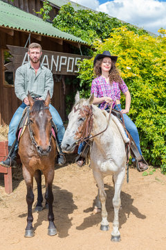 cowboy on horseback couple on background of wooden building