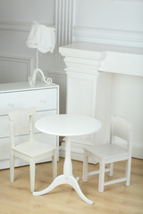 Interior white room with columns in ancient style and different furniture