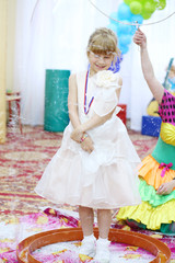 Happy little girl in an elegant dress in a big bubble at the graduation kindergarten