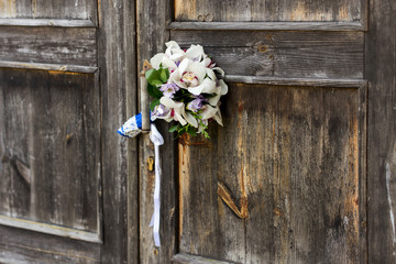 Wedding bouquet on a grey wooden doors