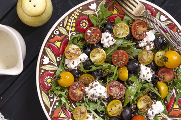 Fototapeta na wymiar Arugula salad with cherry tomatoes feta and olives 