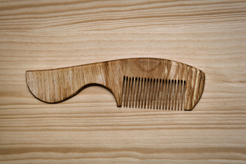 wooden comb on a wooden table. the subject of personal hygiene from environmentally friendly...