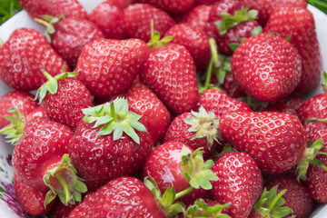 Fresh, red strawberries in plate close up photo.