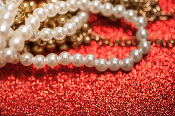 Jewelry background with white pearls on a red glitter