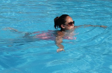 A young lady cooling off in a swimming pool while on vacation, 2016