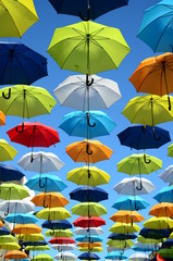 Fototapeta na wymiar Colorful umbrellas background. Colorful umbrellas in the sunny sky. Street decoration.