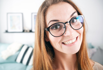 Portrait of nerd woman with big eyeglasses at home