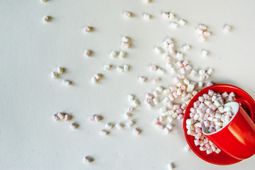 Concept: Christmas mood. Mug filled with marshmallow on a light background. Top view, copy space