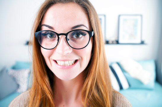 Portrait of nerd woman with big eyeglasses at home