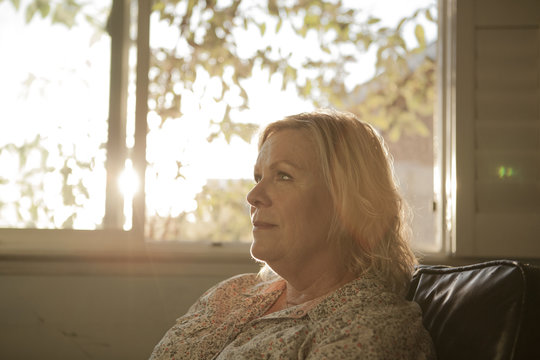 Close up of older woman sitting near window