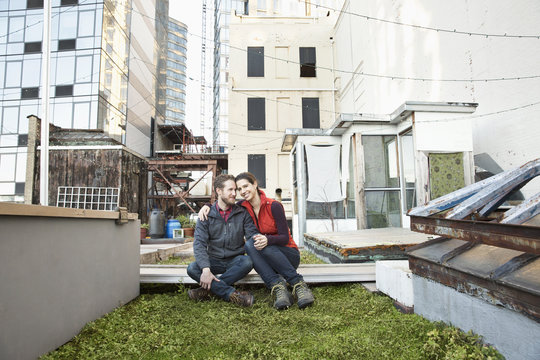 Couple smiling in urban rooftop garden