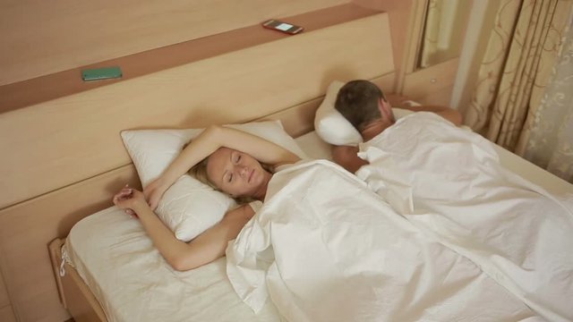 girl looking phone partner while he sleeps. proof of infidelity