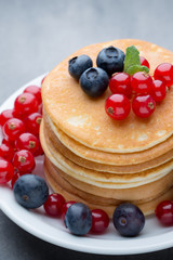 Stack of pancakes with blueberry and fresh berry.