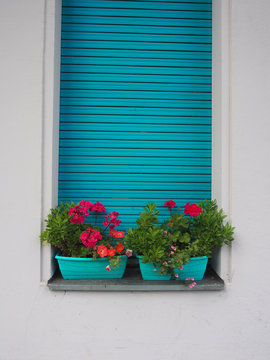 Sommerpause: T&uuml;rkise Rolladen, Poppiger Blumenschmuck