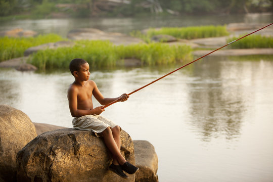 African American boy fishing in lake