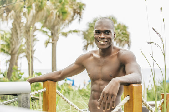 Black man standing on beach walkway