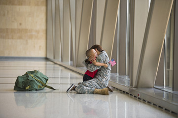 Female soldier hugging son in airport