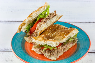 Flatbread tuna sandwich on rustic white wood