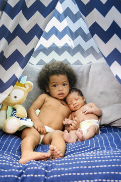 Mixed Race baby boys cuddling on bed