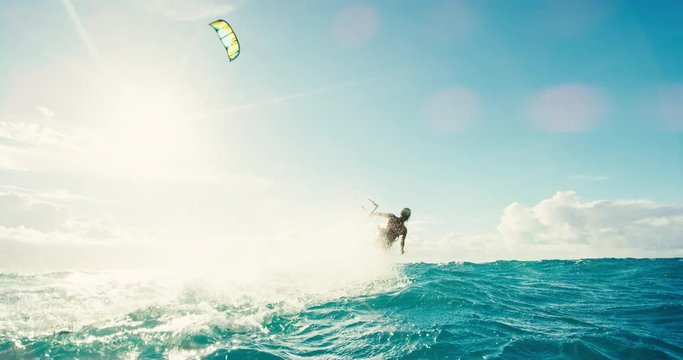 Beautiful young woman kiteboarding at sunset in slow motion, active lifestyle extreme sport