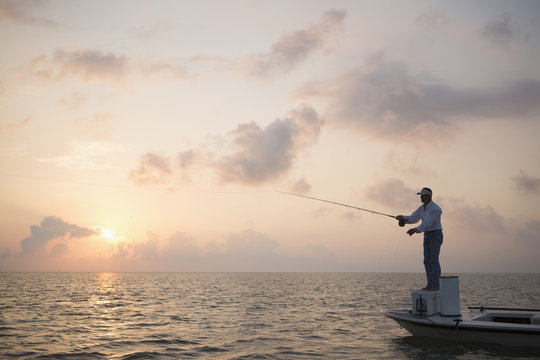 Caucasian man fishing on boat in ocean